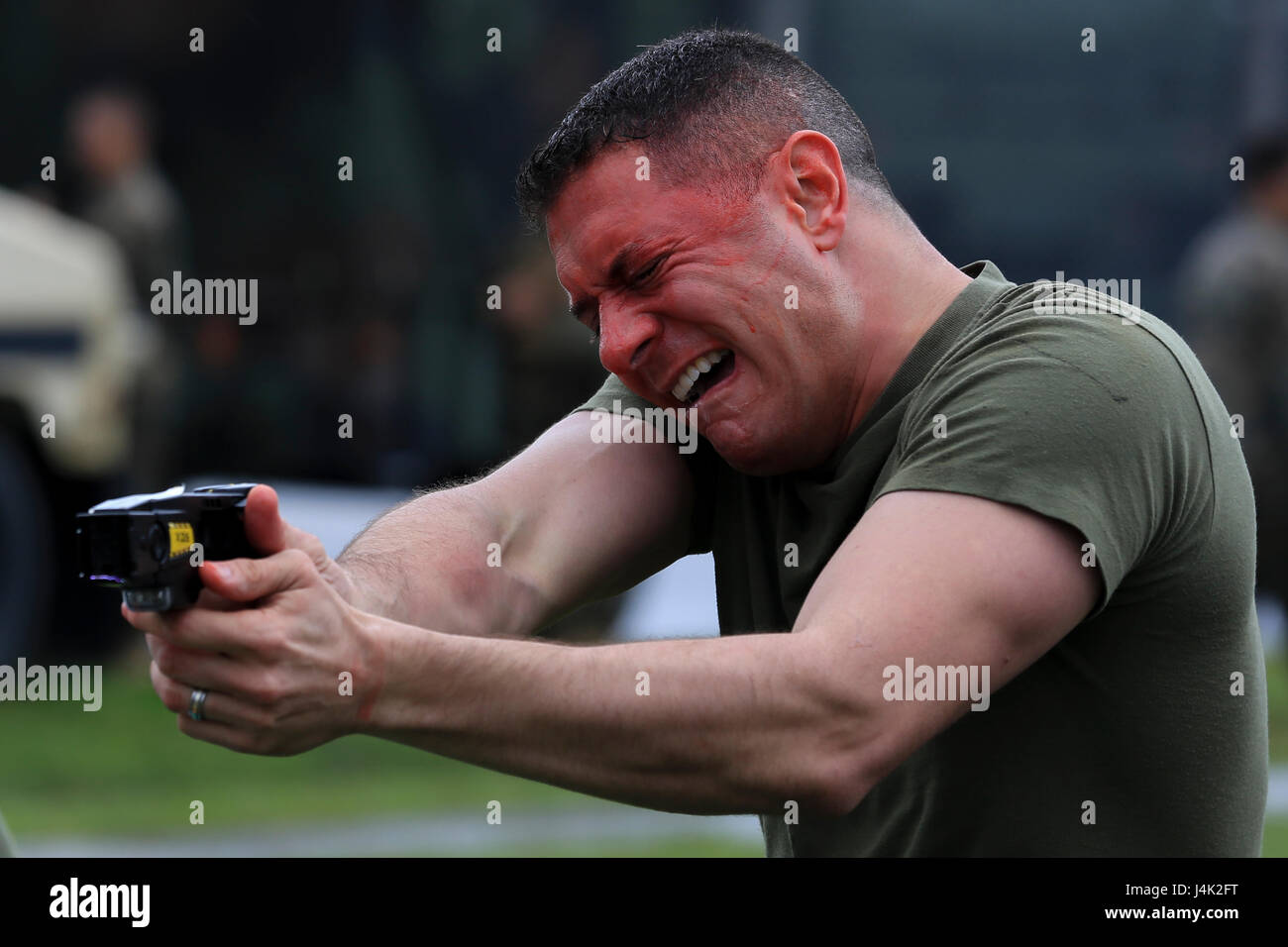 US Marine Gunnery Sgt. Charles Brill, Militärpolizei, zeigt einen Taser auf einen simulierten Aggressor während der Durchführung eines Oleoresin Capsaicin (OC) Exposition Kurs in eine nicht-tödliche Waffen Instructor Kurs an Bord Camp Hansen, Okinawa, Japan, 13. Januar 2017. Der Kurs lehrt Personal die richtigen Techniken bei der Durchführung von Taser Training, OC Exposition und Riot Control Teamtaktik. (Foto: U.S. Marine Corps MCIPAC Bekämpfung der Kamera CPL. Allison Lotz/freigegeben) Stockfoto