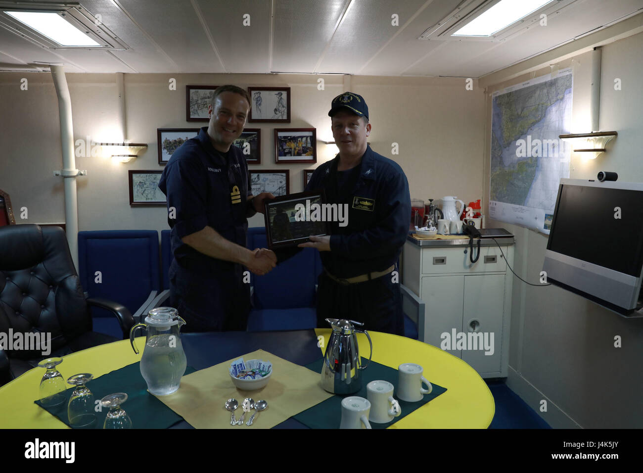 Die Befehlshaber der USS Bataan (LHD 5) und der Royal Navy Fregatte HMS Monmouth tauschen während der Übung Alligator Dagger 17 im US 5th Fleet Area Geschenke aus. Stockfoto