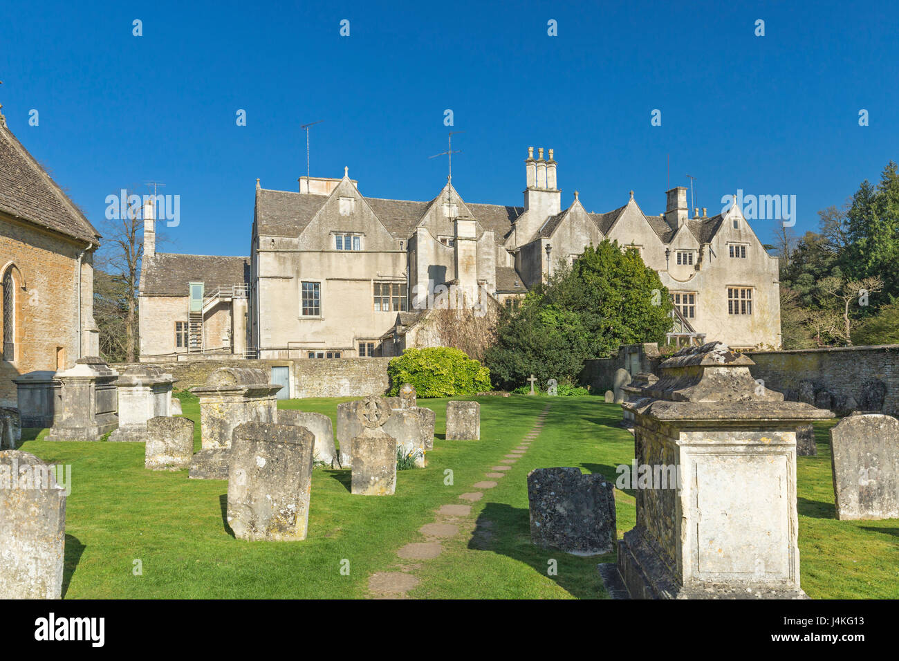 Historische Gebäude, die über den Friedhof in Cotswolds von England sehen Stockfoto