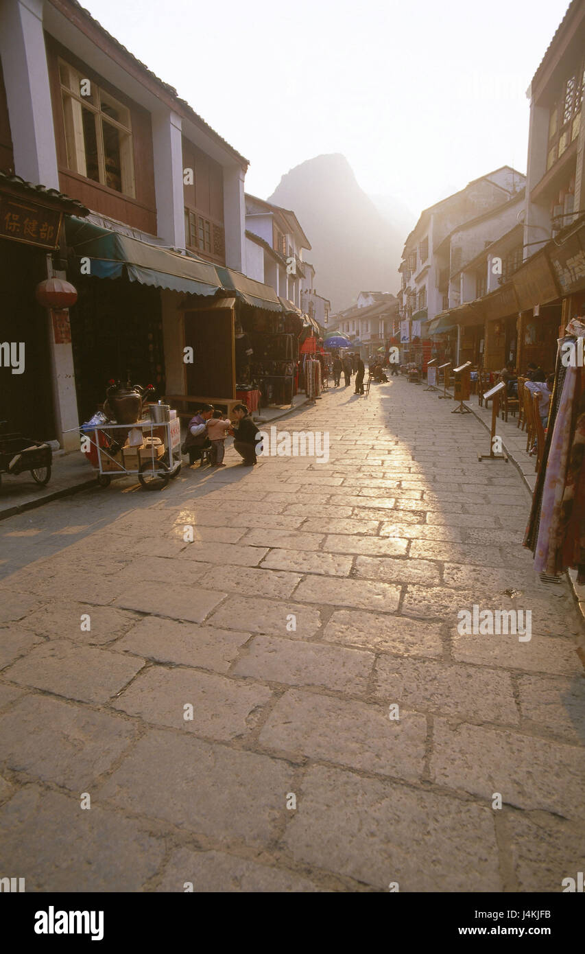 China, Provinz Guangxi, Guilin, Yangshou, Straße geschäftlich, abends leichte Asien, Ostasien, Zhonghua Renmin Gongheguo, Volksrepublik, Stadt, Straße, shopping Street, Geschäfte, Passanten, Hintergrund, mountain Stockfoto