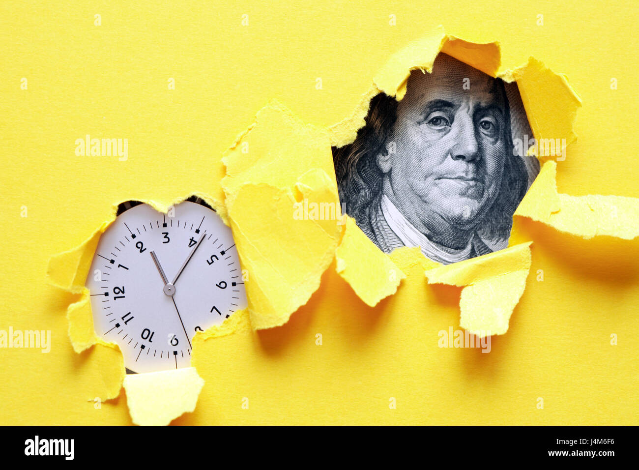 Zeit ist Geld. Uhr und hundert-Dollar-Banknote in Löcher in gelbem Papierblatt Stockfoto