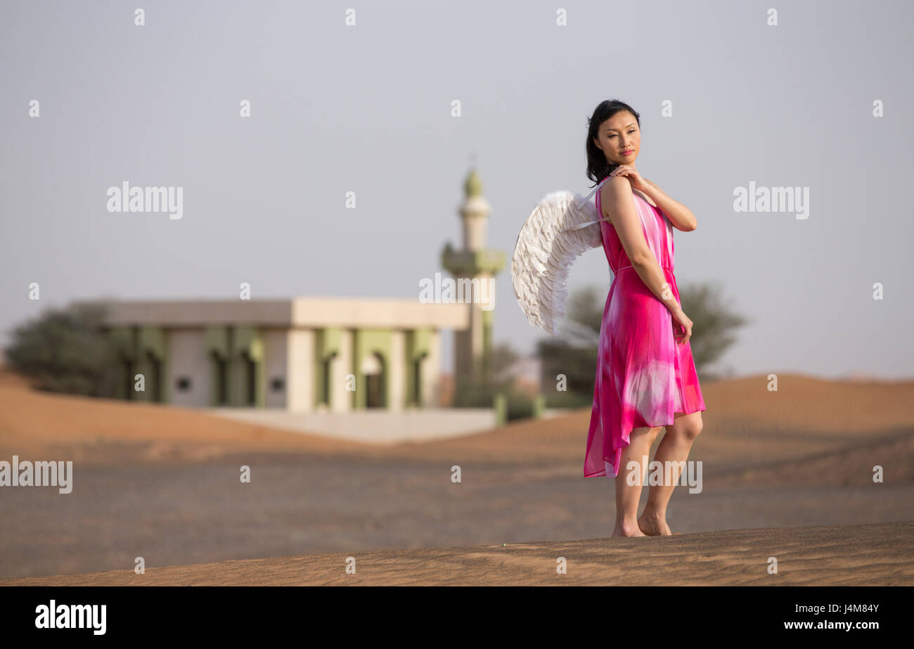 junge Frau mit Winkel Flügel in einer Wüste Stockfoto