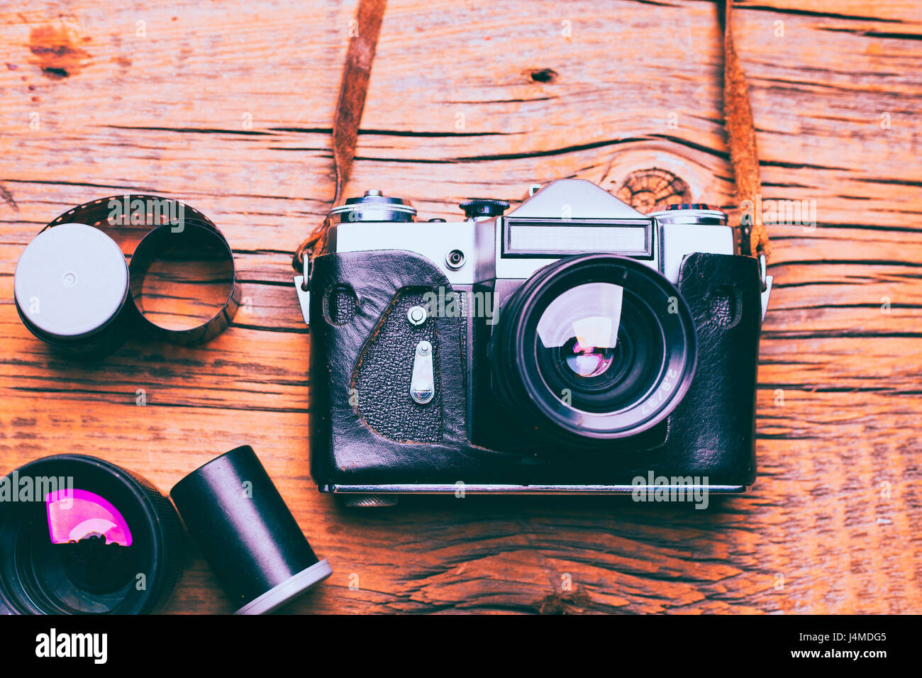 Kamera mit Objektiv und Film auf Holztisch Stockfoto