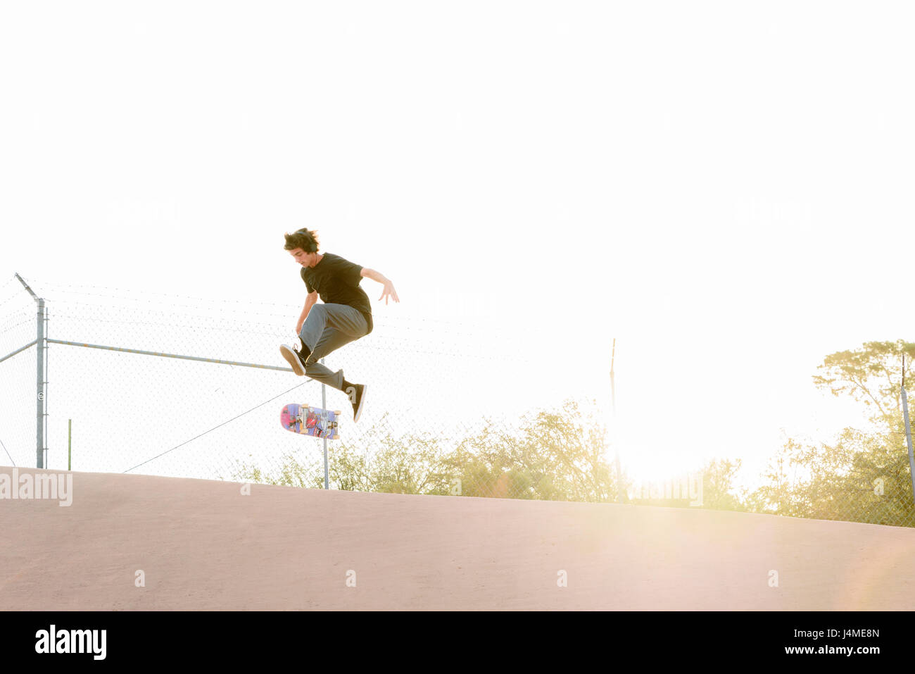 Hispanic Mann Durchführung der Luft Trick auf skateboard Stockfoto