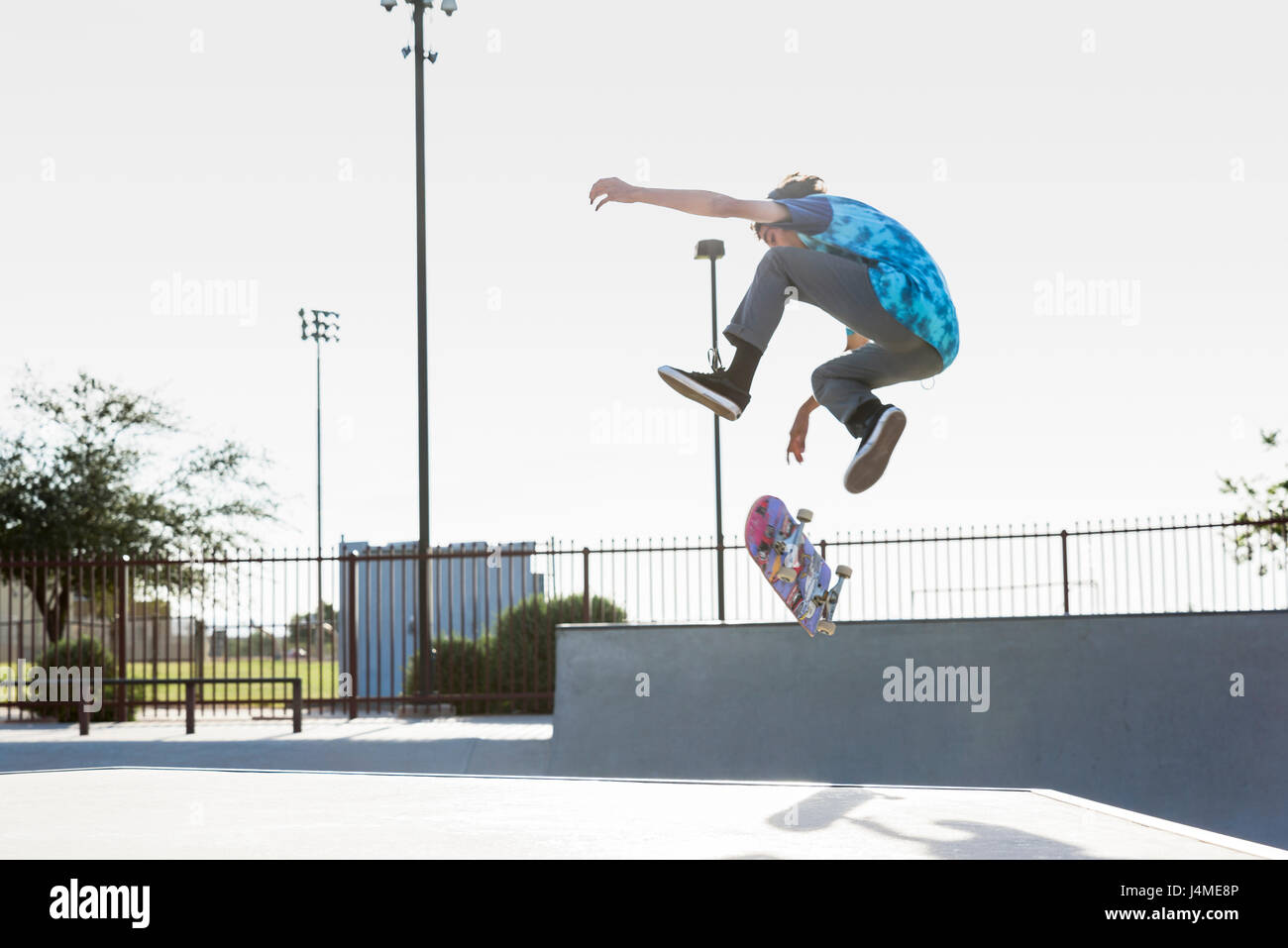 Hispanic Mann Durchführung der Luft Trick auf skateboard Stockfoto