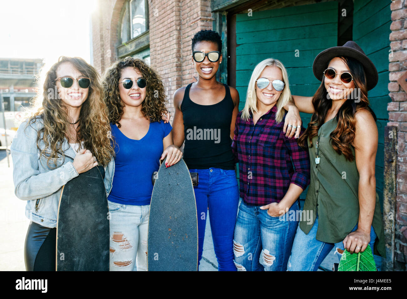Frauen posieren mit Skateboards in Stadt Stockfoto