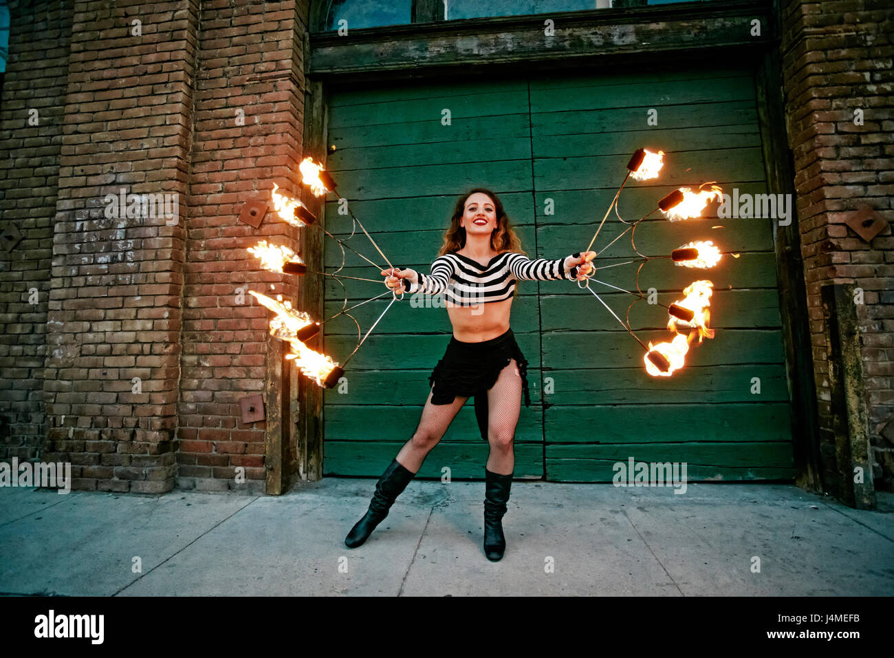 Kaukasische Frau jonglieren Feuer auf Stadt Bürgersteig Stockfoto