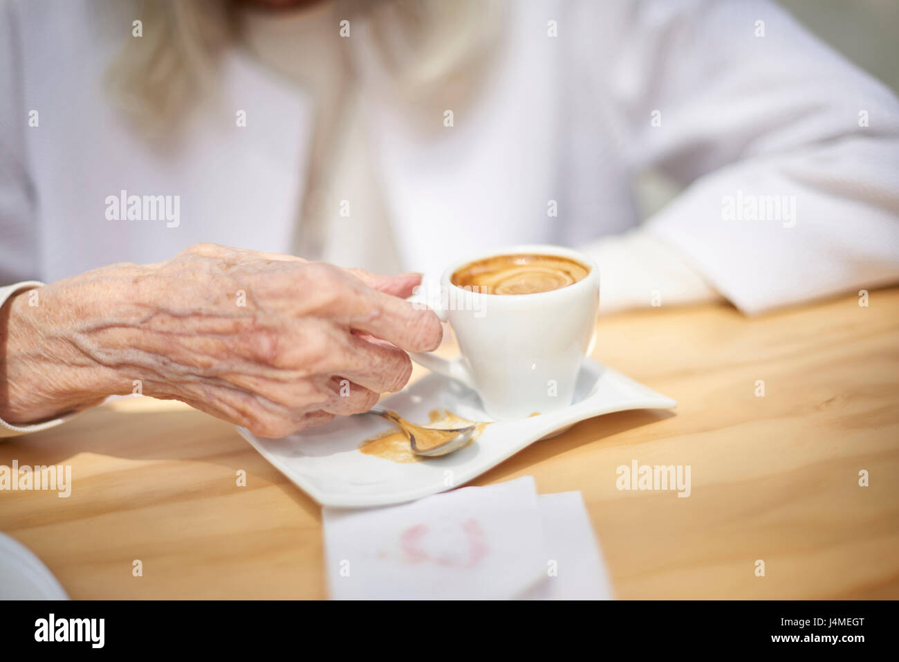 Hand des älteren kaukasischen Frau Kaffee trinken Stockfoto