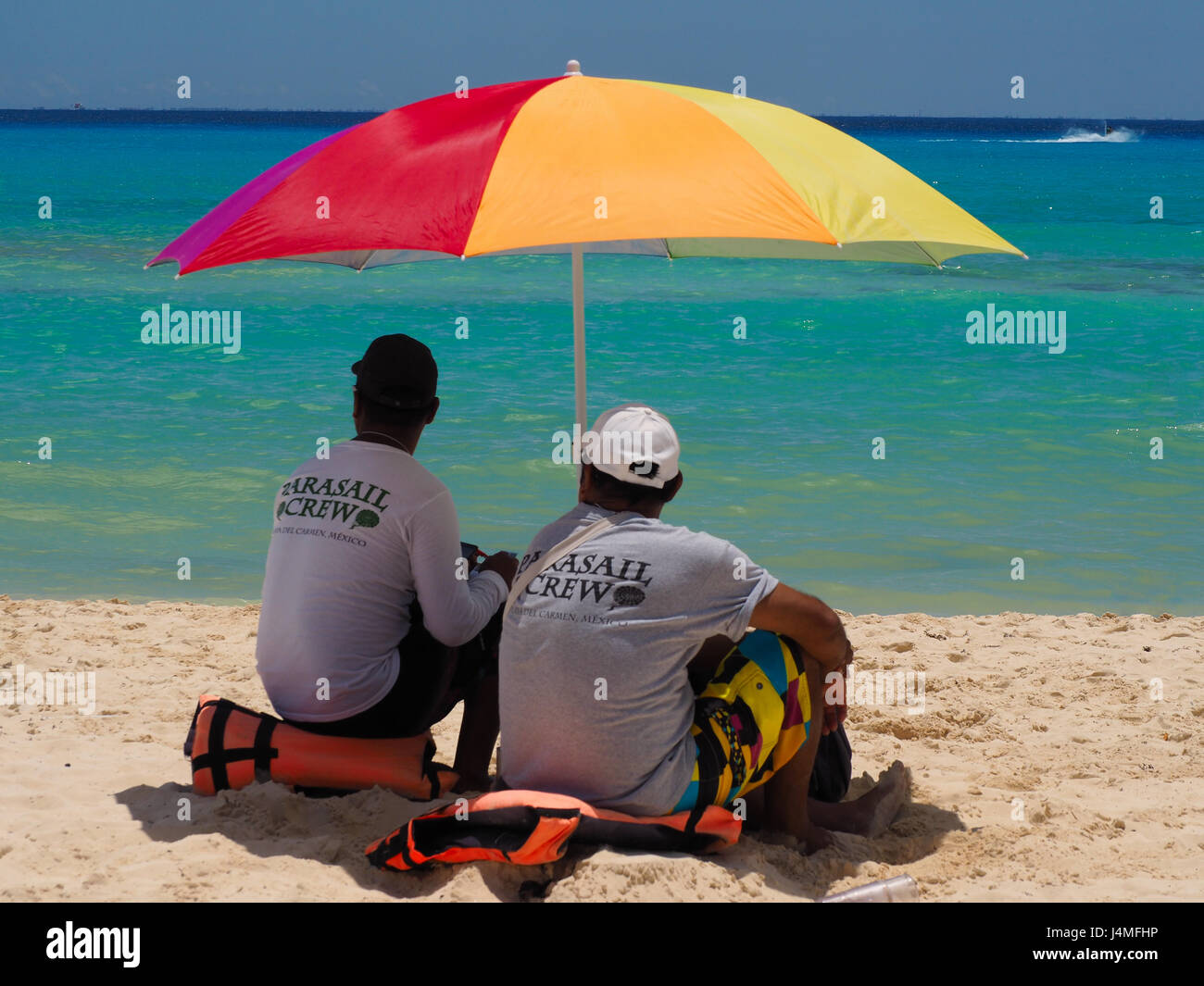 Strandverkäufer bergende unter Strand brolly Stockfoto