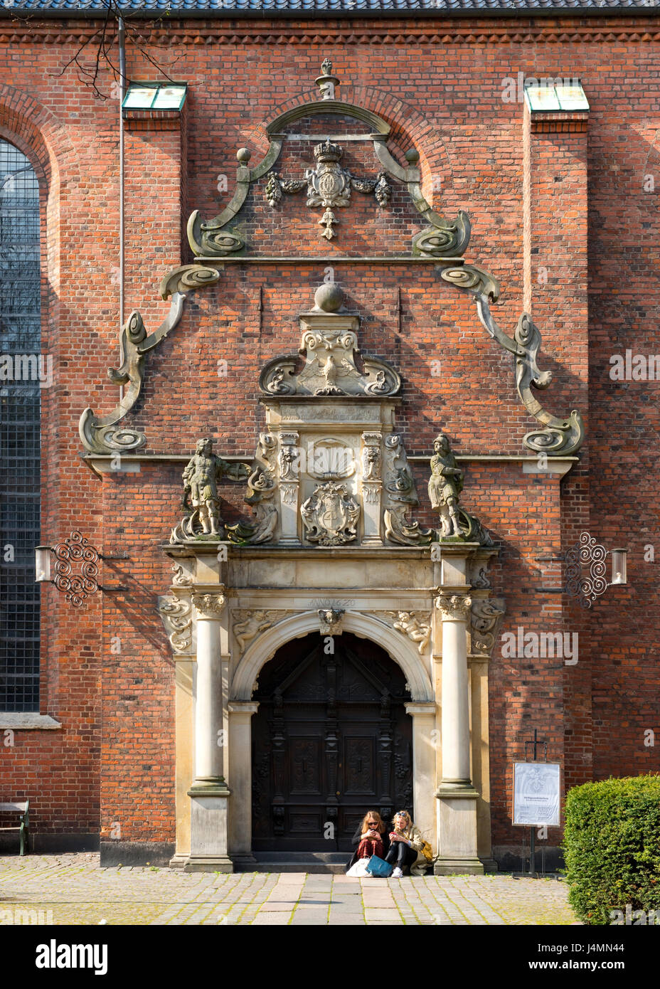 Freunde auf Eingangsstufen der Kirche des Heiligen Geistes, Helligåndskirken.Copenhagen, Dänemark Stockfoto