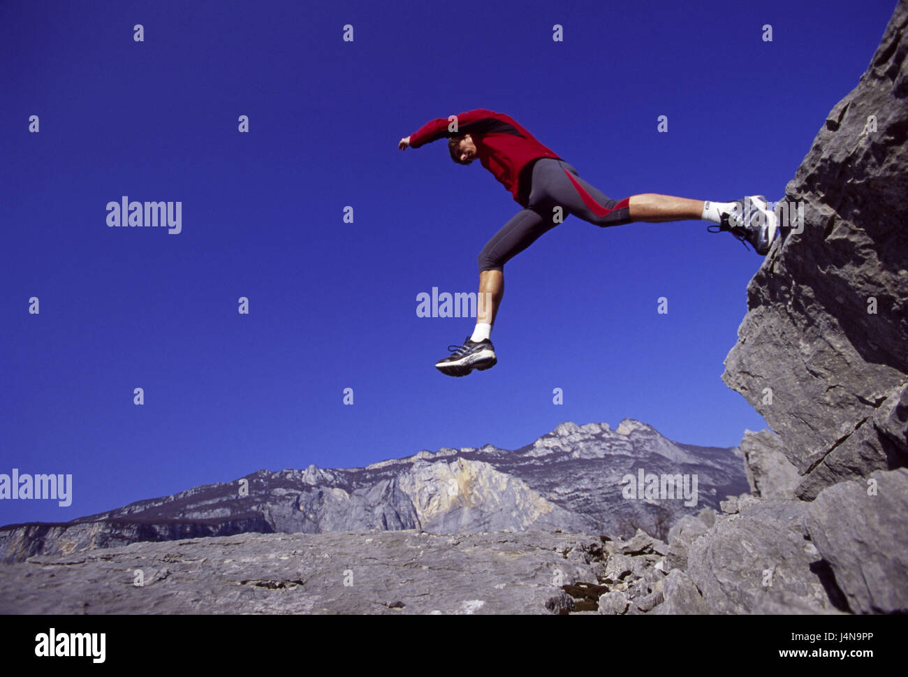 Italien, Trentino, Jogger, Sportler, Sprung, Felsen, Berglandschaft Stockfoto