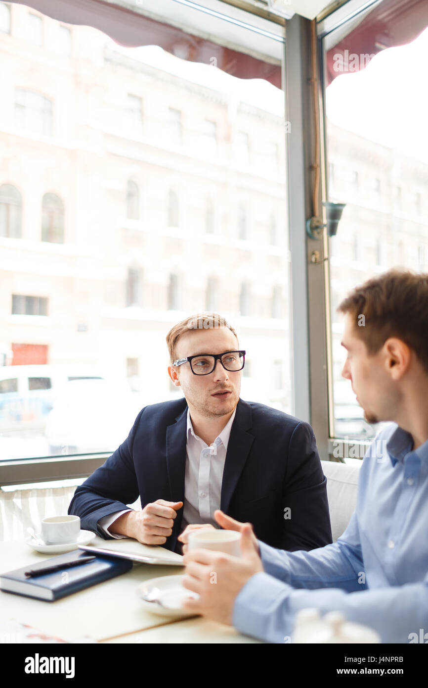 Porträt des jungen Mann mit großer Brille Beratung Client am Tisch im café Stockfoto