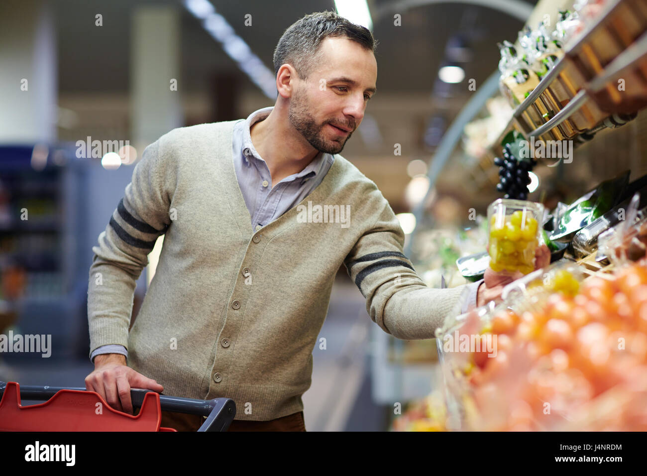 Porträt des Lächelns gut aussehender Mann Einkaufen im Supermarkt, Regal Lebensmittel auswählen Stockfoto