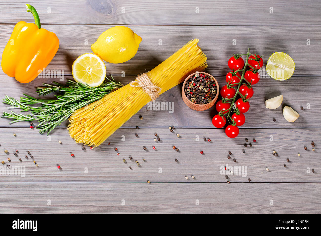 Spaghetti, Cherry Tomaten, Olivenöl und Gewürzen auf alten grauen Hintergrund Holz Stockfoto