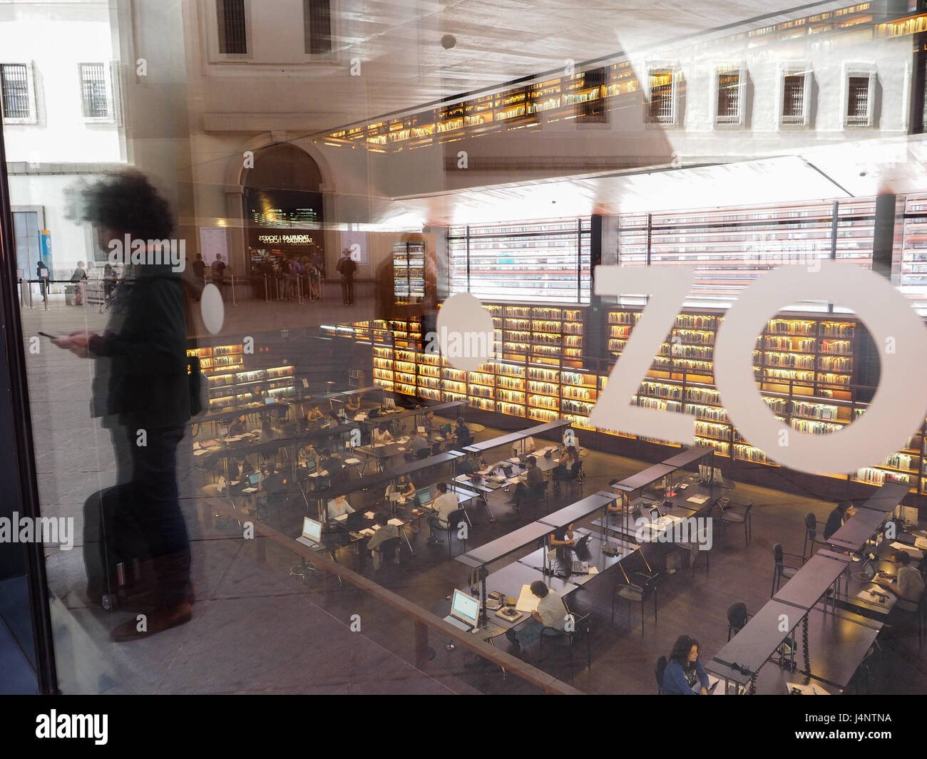 ein Blick durch das Fensterglas nach unten in die Bibliothek an der Architektur des Museums Museo Reina Sofia, mit einer Person in die Glasscheibe in Ma wider Stockfoto