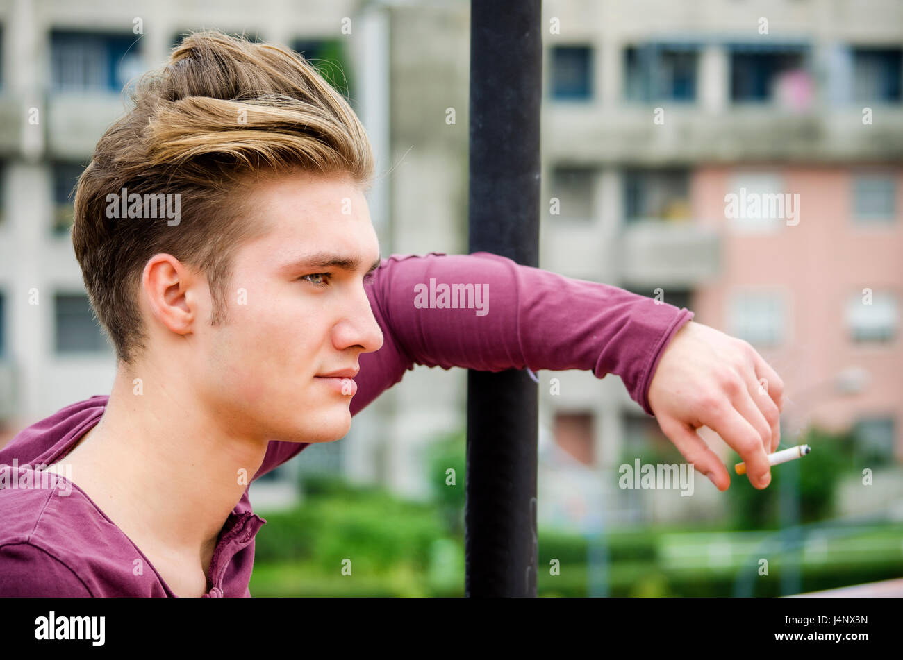 Attraktive blaue Augen, blonde junge Mann Rauchen Stockfoto