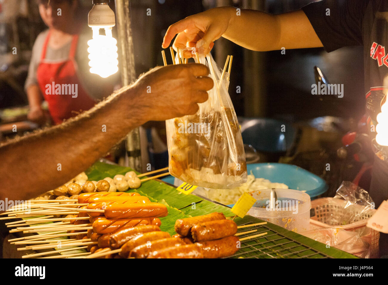 CHIANG MAI, THAILAND - 21 AUGUST: Mann kauft Frikadellen auf dem Sonntagsmarkt (Walking Street) am 21. August 2016 in Chiang Mai, Thailand. Stockfoto