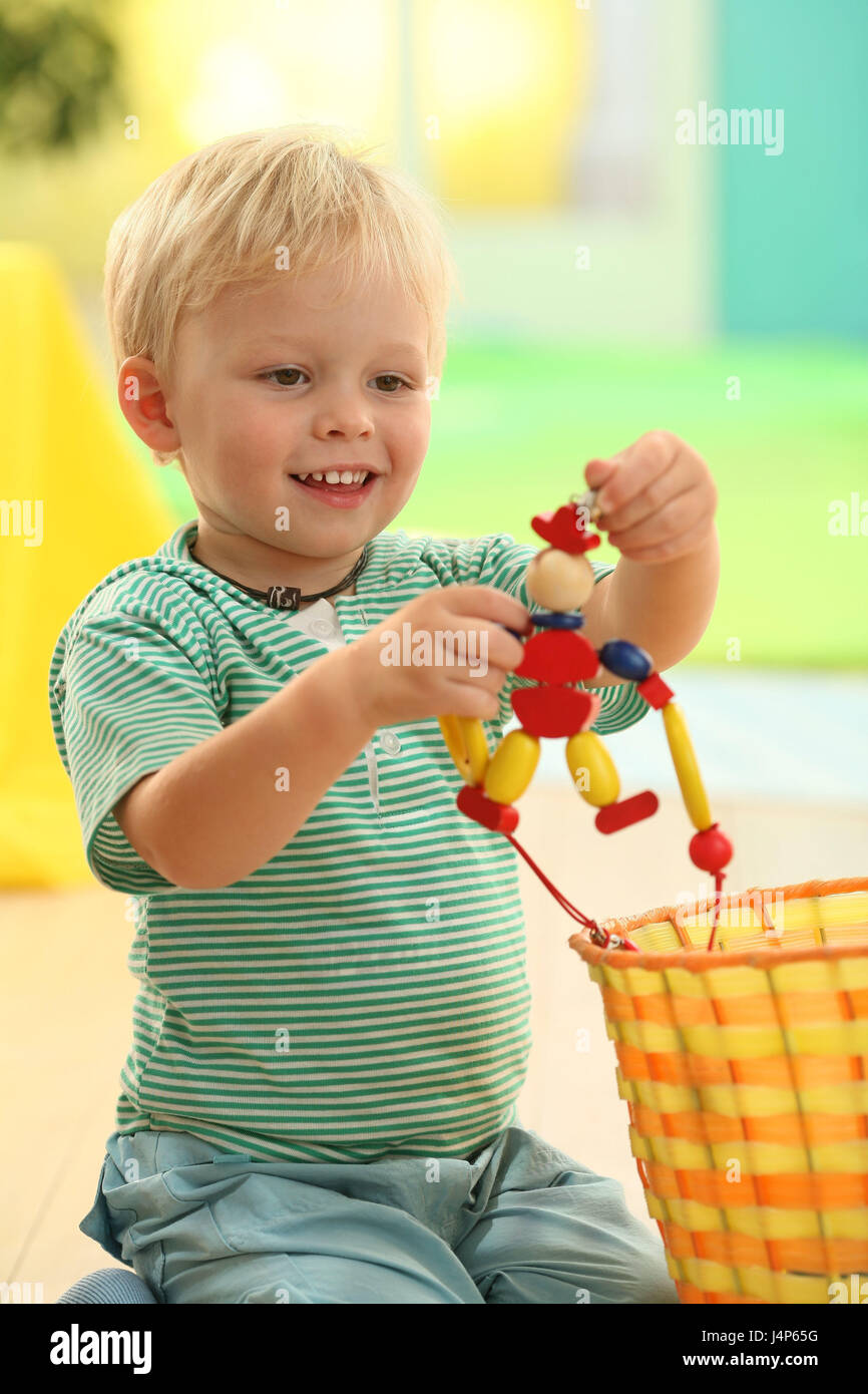 Kleinkind, junge, 3 Jahre, spielen, Spielzeug, Modell veröffentlicht, Menschen, Kind, Kind, Kleid, berührt, blond, Entdeckung, Indoor, Lächeln, lernen, neugierig, spielen, Holzspielzeug, Hampelmann, Stockfoto