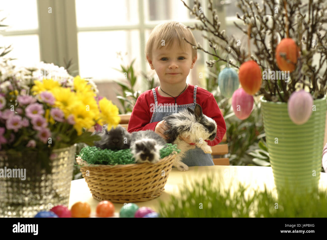 Kind mit Kaninchen in Oster-Deko, Modell veröffentlicht, Stockfoto