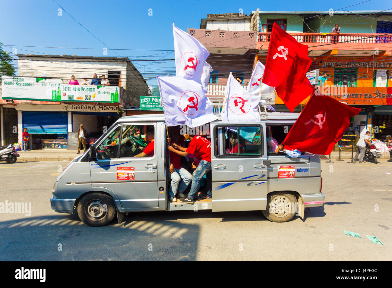 Pokhara, Nepal - 11. Mai 2017: Maoistischen Kommunistischen Partei Mitglieder wehende Fahnen befestigt zum Transporter während der Kampagne für die nationalen Wahlen 2017 Stockfoto