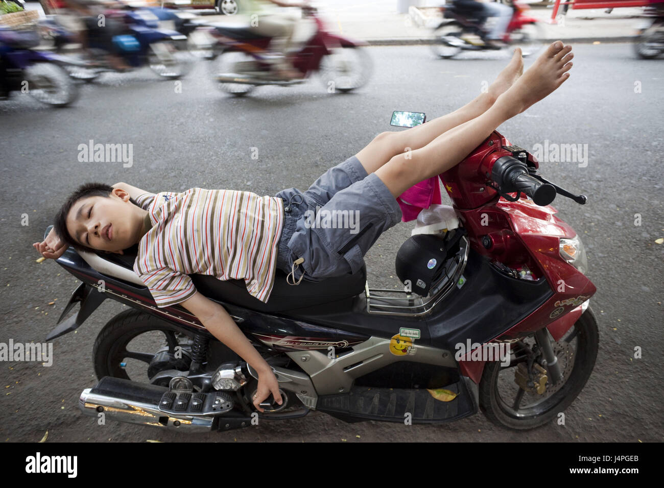Vietnam, Ho-Chi-Minh-Stadt, junge, auf dem Motorrad Sleeping, kein Model-Release Stockfoto
