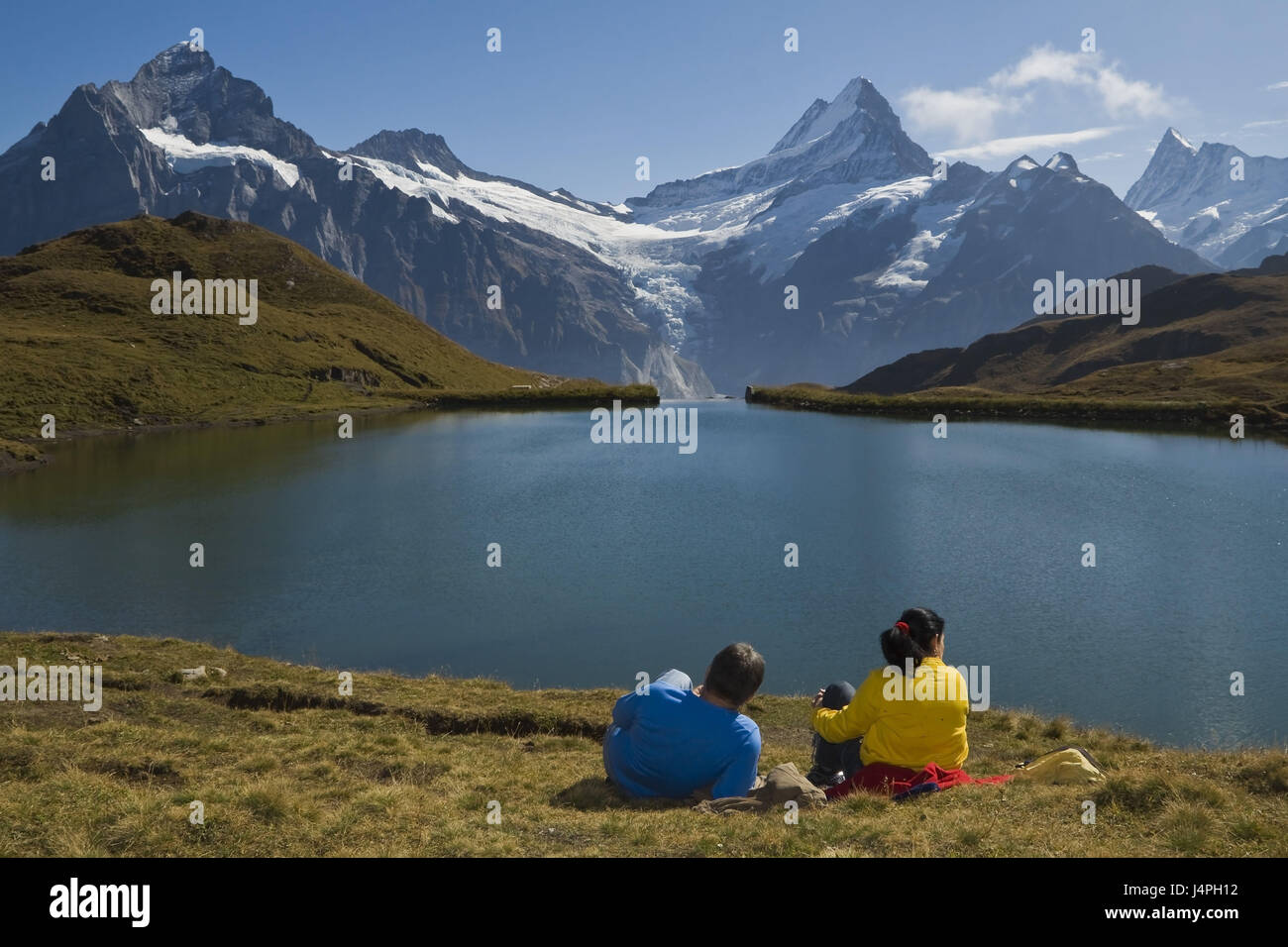 Bergsee, Alpenpanorama, paar, sitzen, Rückansicht, Picknick, Alpine Rasen, Verbrauch, Landschaft, Schau mal, der Schweiz, die Berner Alpen, Grindelwald, brook Alpsee, kein Model-Release Stockfoto