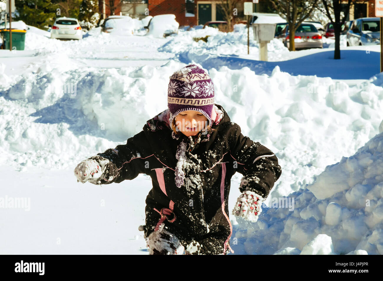Kleines Mädchen mit Schnee spielen kleine Mädchen spielen auf der Straße mit Schnee Stockfoto
