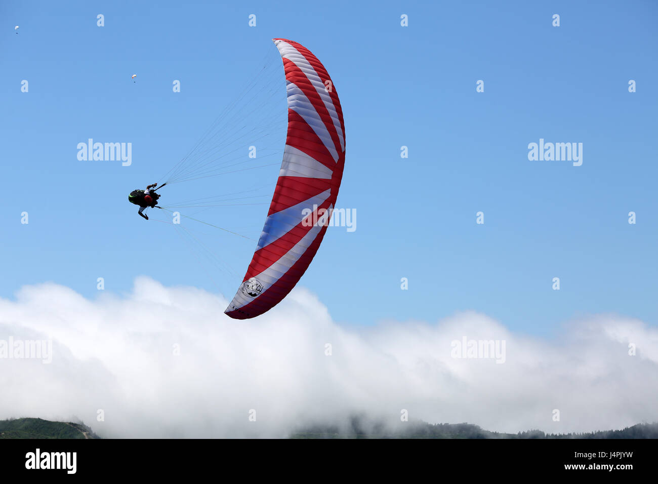 Ein Paragliding Acro Piloten fliegen während der 22. Azoren Paragliding Festival am Lagoa Das Sete Cidades in São Miguel, Azoren, Portugal. Stockfoto