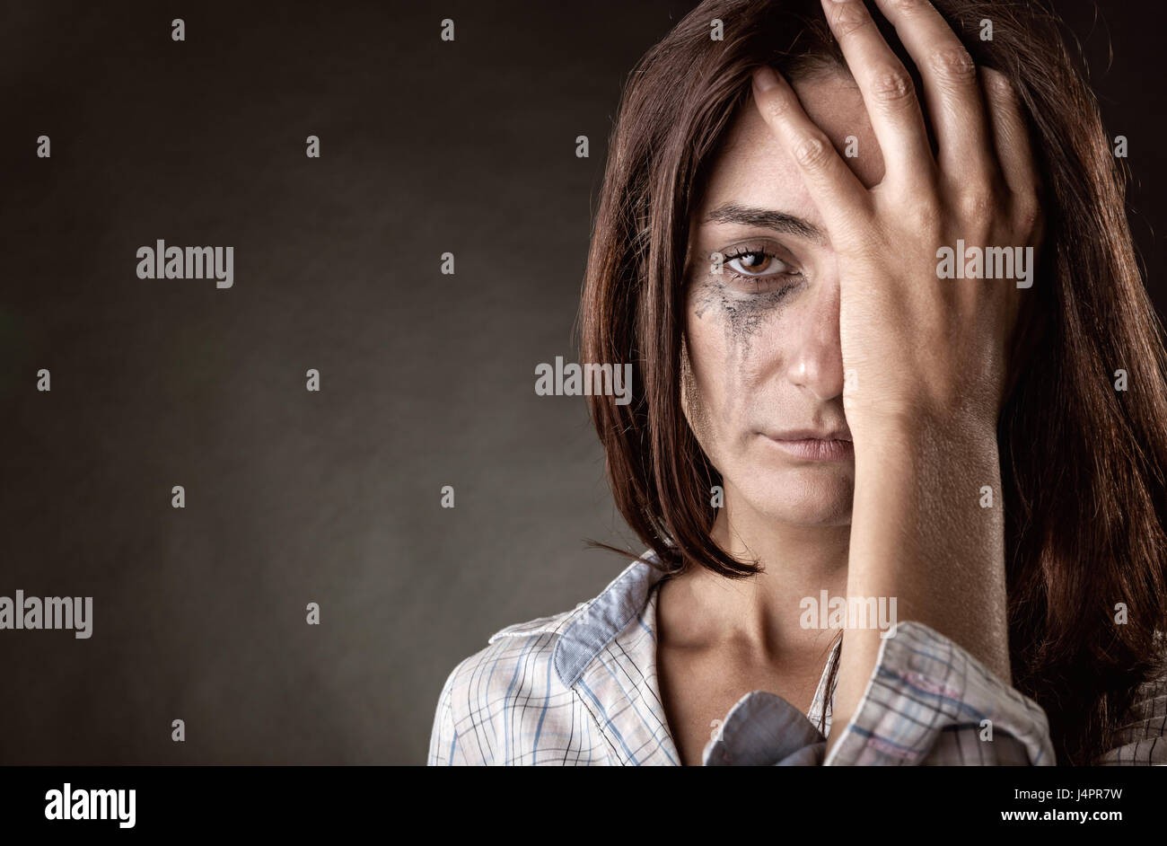 Weinendes Mädchen auf einem dunklen Hintergrund Stockfoto