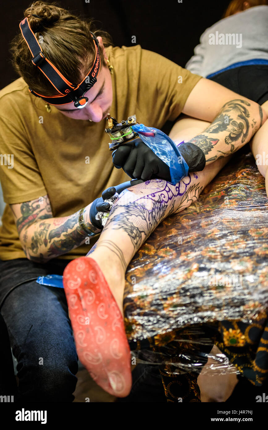 Tattoo-Künstler arbeitet auf einem Client an der 10. jährlichen Brighton Tattoo Convention, The Brighton Centre, Brighton. Foto © Julia Claxton Stockfoto