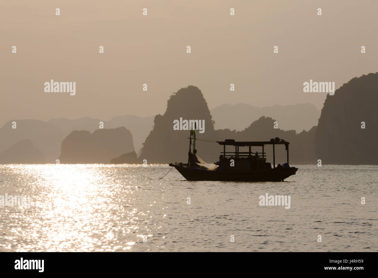 Vietnam, Halong Bay, Schiff, Silhouette, Abendlicht, Stockfoto