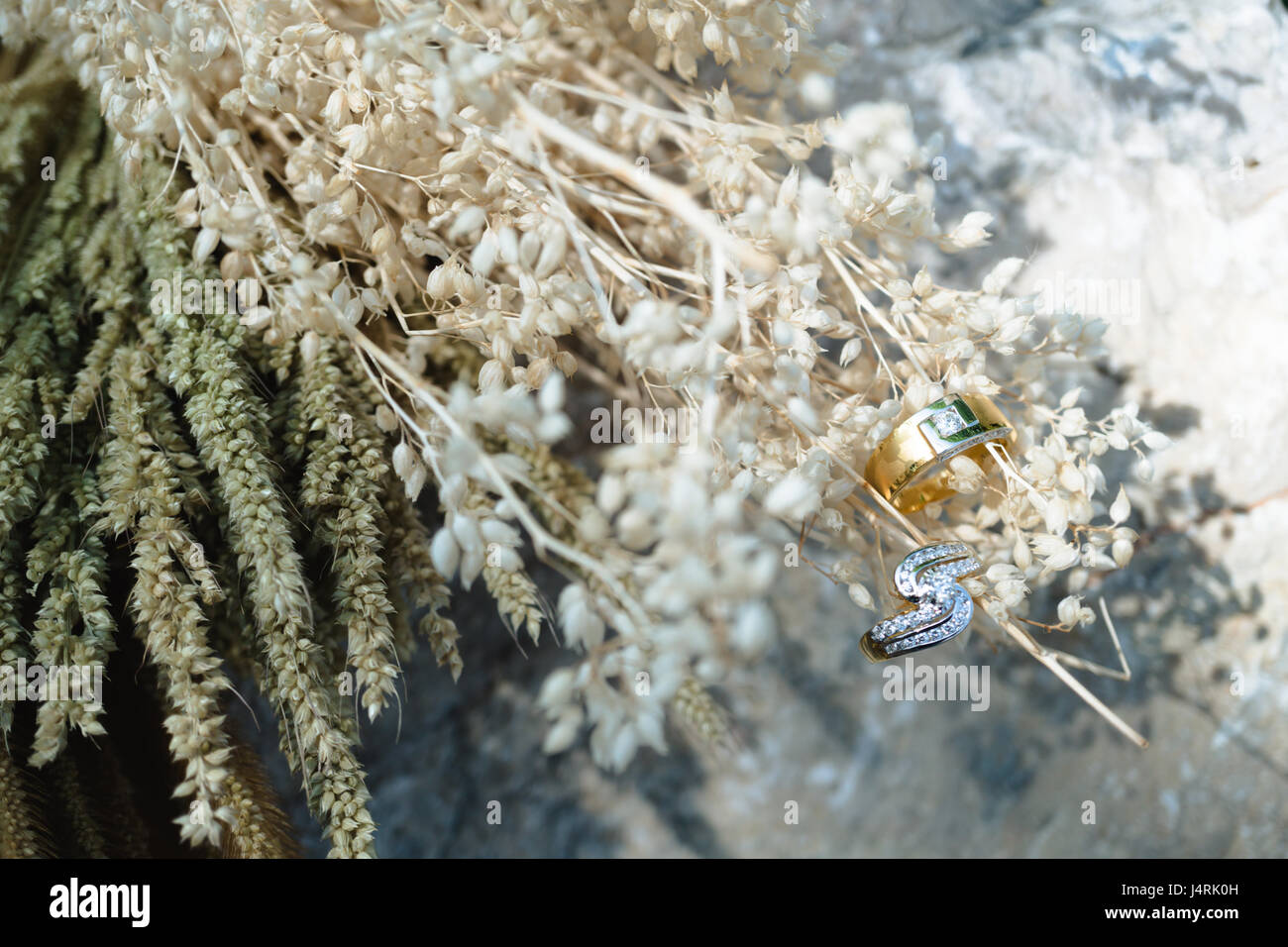 Paar Diamant-Ringe hängen getrocknete Blumen Bukett, für Liebe oder Valentinstag-Konzept. Stockfoto