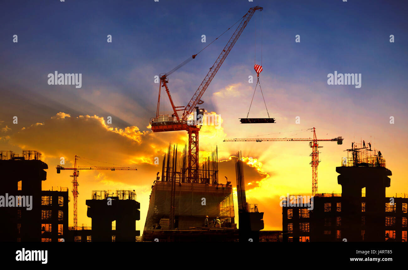 großen Kran und Hochbau gegen schönen düsteren Himmel Einsatz für Bauindustrie und Maschinenbau Stockfoto