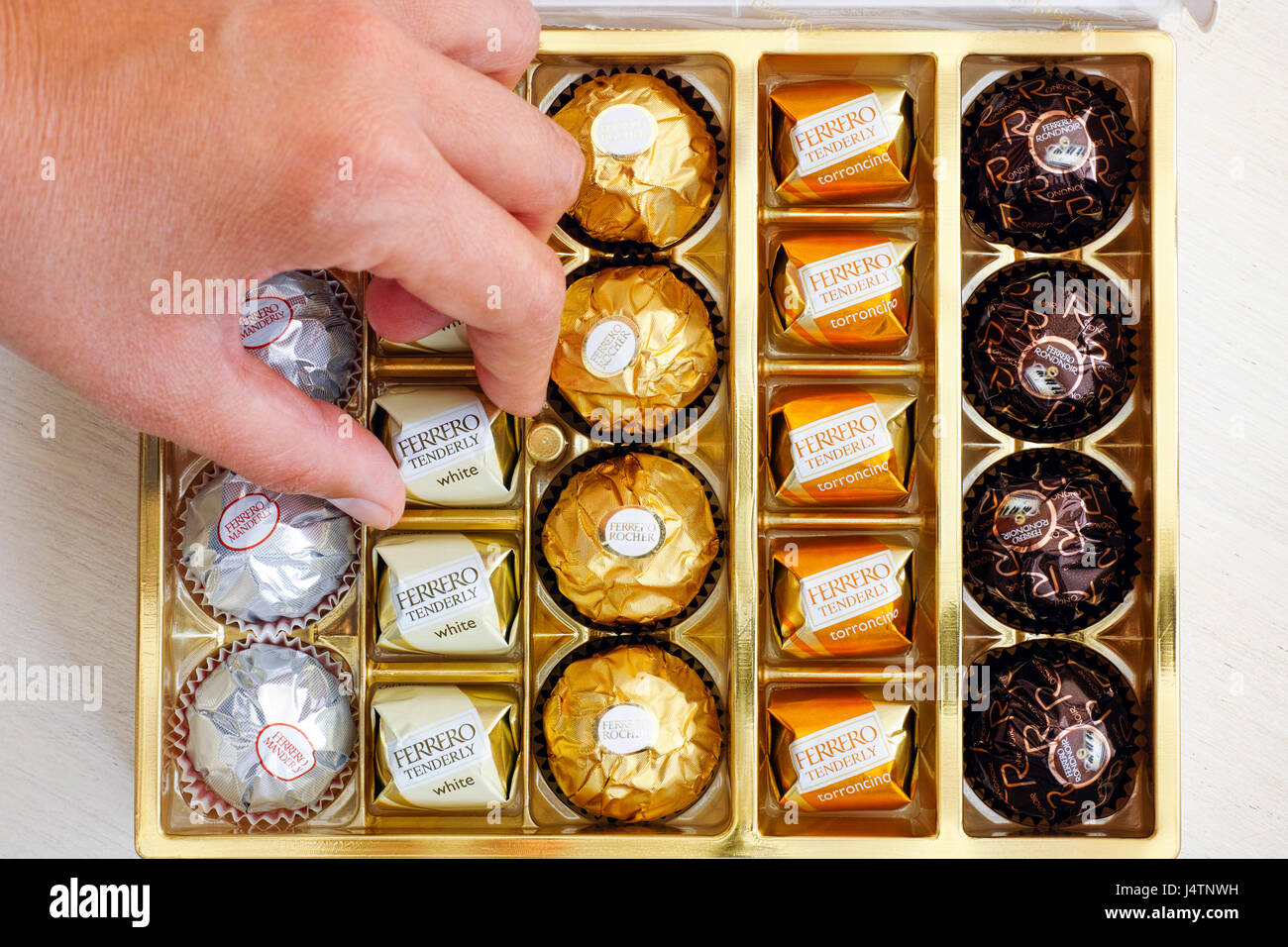 Paphos, Zypern - 20. November 2016 Frau Hand nehmen Süßigkeiten Ferrero zärtlich aus Karton von Ferrero Süßigkeiten. Stockfoto