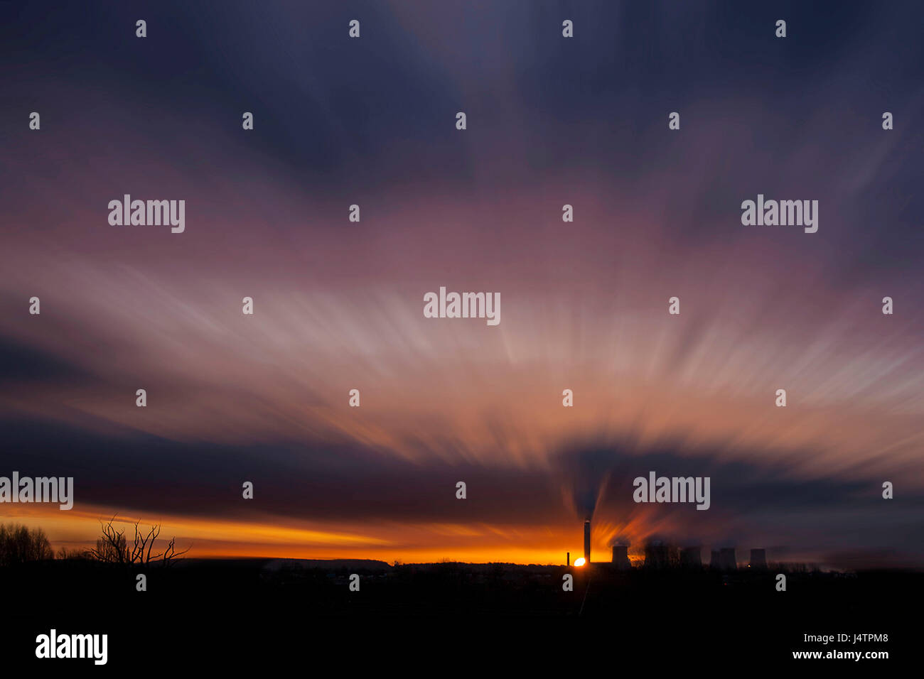 Eine bunte, verschwimmen Himmel Sonnenuntergang über ein Kraftwerk. Stockfoto