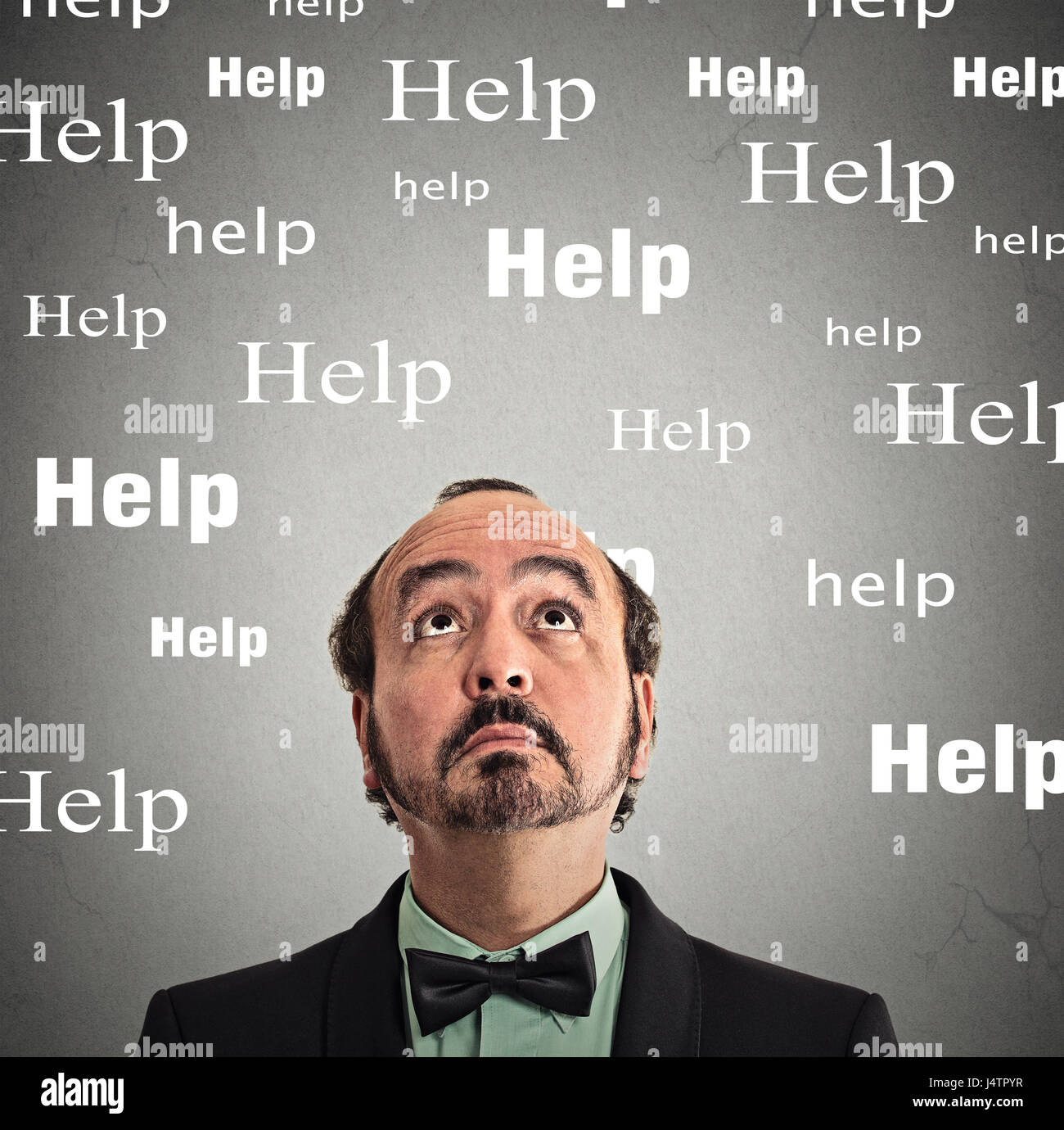 Closeup Kopfschuss Mann suchen Hilfe auf graue Wand Hintergrund isoliert Stockfoto