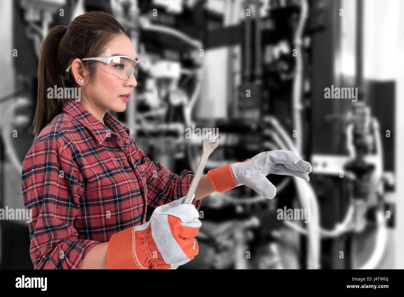 Junge Bäuerin mit offenem Ende Schraubenschlüssel. Augmented-Reality-Brille-Technologie, Industrie 4.0-Konzept. Stockfoto
