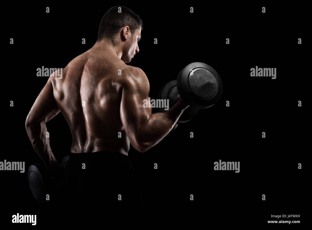 Sportlicher Mann Training Bizeps auf schwarzem Hintergrund Stockfoto