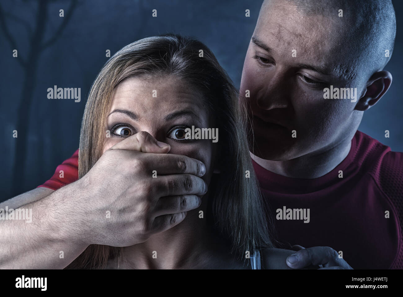 Häusliche Gewalt-Frau missbraucht und erwürgt von starker Mann in einem dunklen Wald Stockfoto