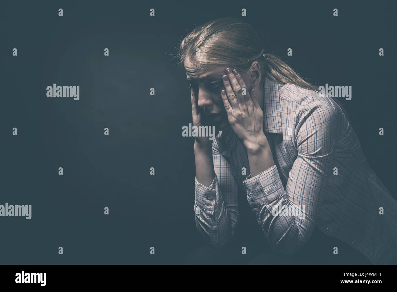Trauriges Mädchen auf einem schwarzen Hintergrund Stockfoto