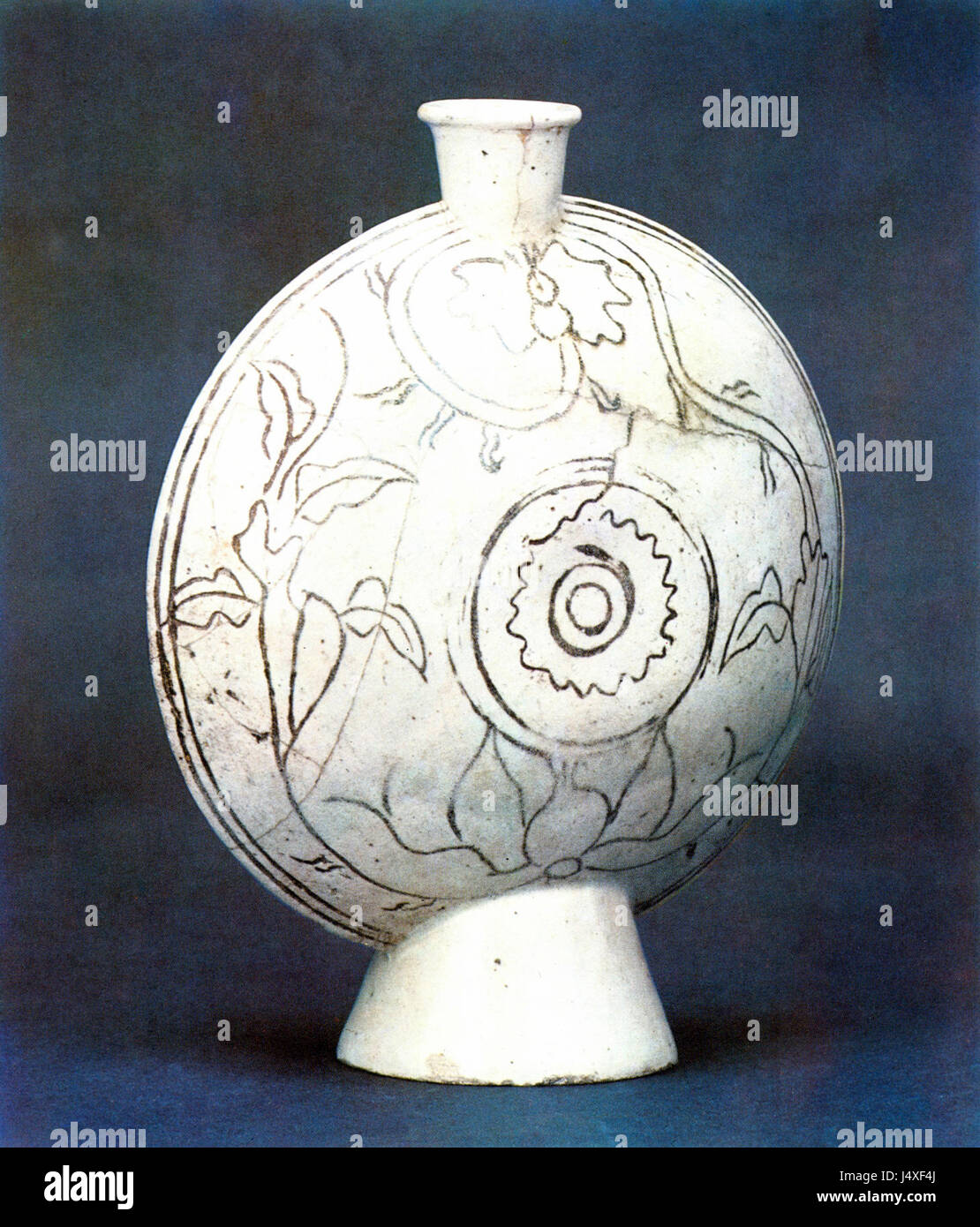 Diese flache Flasche aus weißem Porzellan bietet komplizierte Einlegedesigns aus Blumen und Gras, die Handwerkskunst aus einer unbekannten Region zeigen. Die zarte Dekoration unterstreicht die Schönheit der Natur durch traditionelle Keramikkunst. Stockfoto
