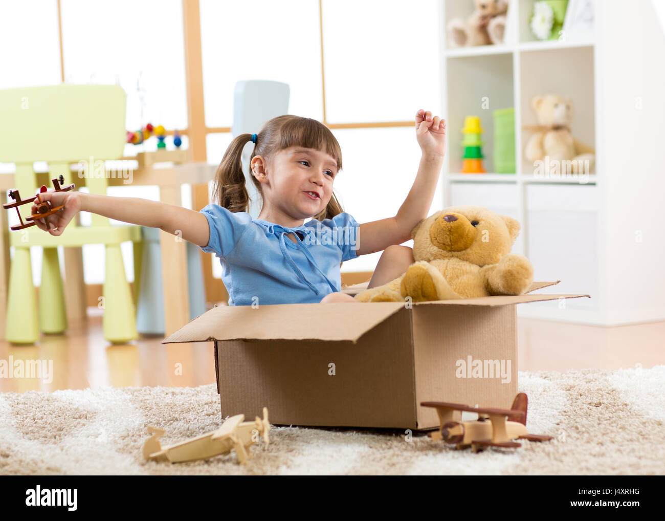 Kind spielt mit dem Flugzeug Spielzeug zu Hause. Reisen, Freiheit und Phantasie Konzept. Stockfoto