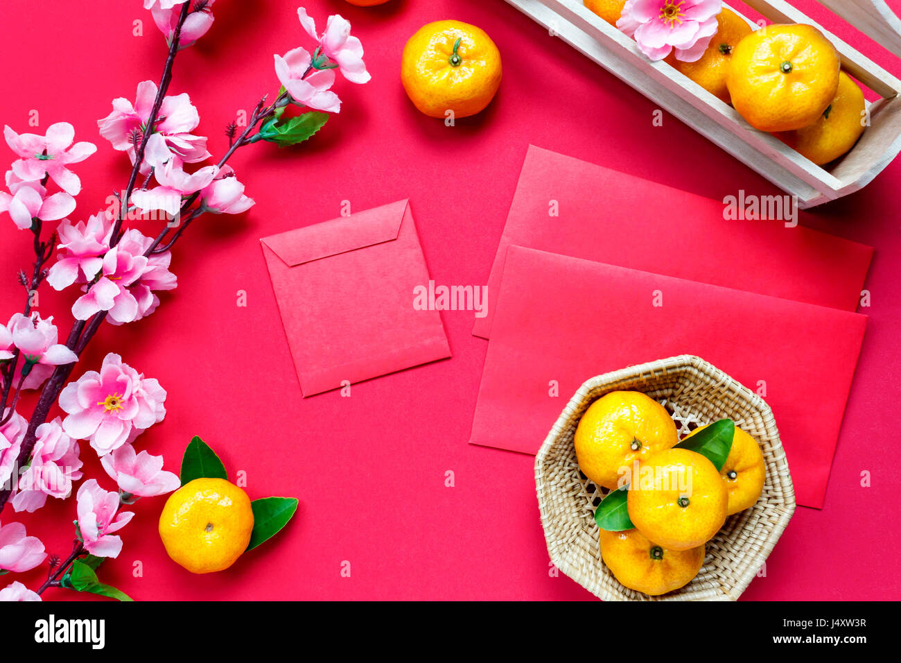 Top Zubehör Chinese New Year Festival decorations.orange,leaf,wood Warenkorb ansehen, rote Päckchen, Pflaumenblüte auf rotem Grund. Stockfoto