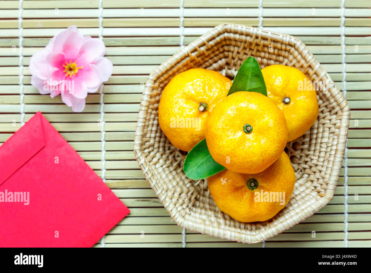 Top Zubehör Chinese New Year Festival decorations.orange,leaf,wood Warenkorb ansehen, rote Päckchen, Pflaumenblüte auf Bambus Hintergrund. Stockfoto