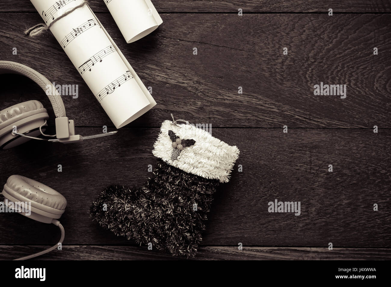 Draufsicht Weihnachten Musik Notizpapier mit Weihnachtsdekoration und Kopfhörer auf Holztisch Hintergrund. Erschaffen Sie dieser Hinweis Notenpapier selbst. Stockfoto