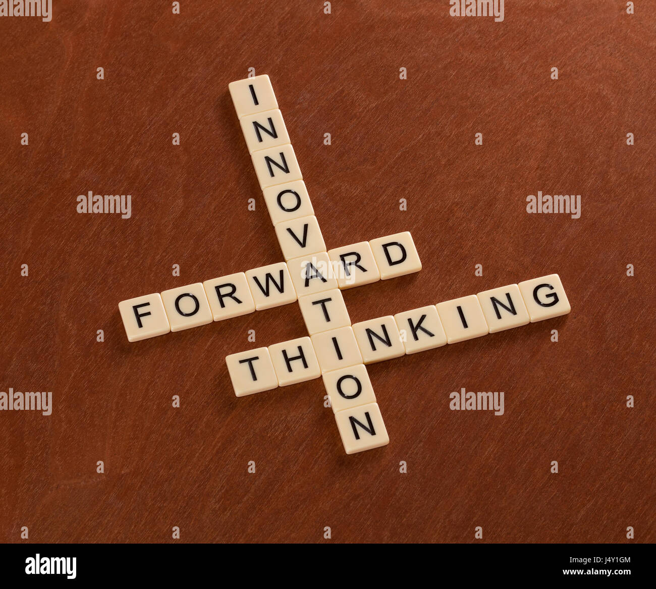 Kreuzworträtsel mit Worten Innovation, Forward, denken. Innovativ sein Konzept. Elfenbein Fliesen mit Großbuchstaben auf Mahagoni Brett. Stockfoto