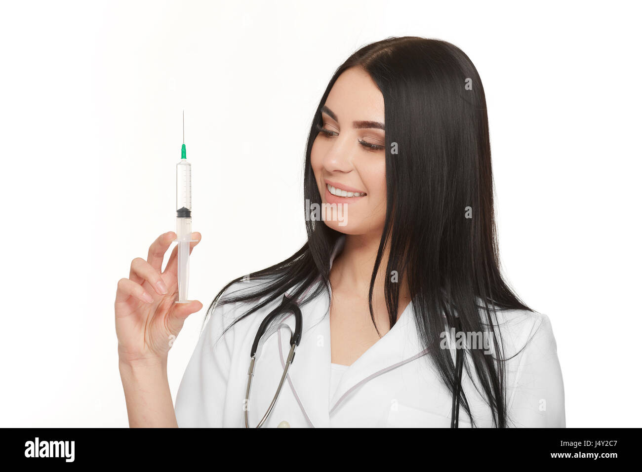 Ein Porträt von einer jungen Ärztin lächelnd mit einer Spritze in der hand Stockfoto