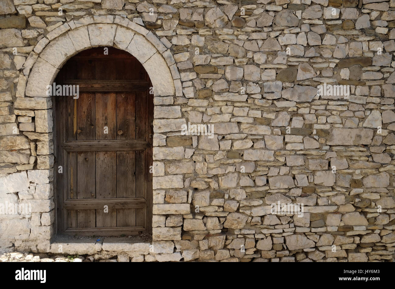 Steinmauer mit alten Holztür in der alten Stadt Berat, Albanien am 1. Oktober 2016. Stockfoto