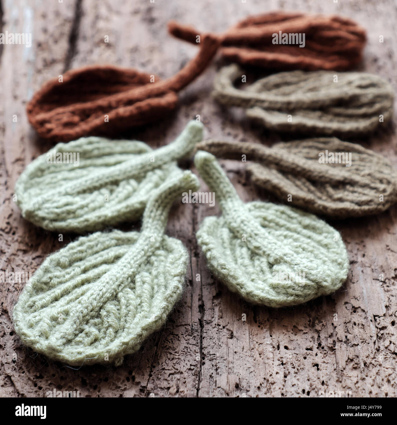 Erstaunliche handwerkliche Produkte aus Garn, Gruppe gestrickt Winter Blatt auf hölzernen Hintergrund, Schönheit Erle Blatt mit Vintage-Ton, Wollstoff handgefertigt für den winter Stockfoto