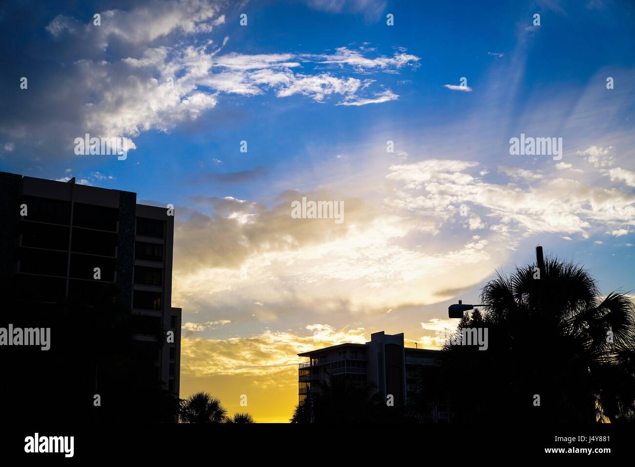 Der Himmel ist mit brillanten Farben erfüllt, wie die Sonne untergeht hinter diesen aufbauend auf Venedig im Südwesten von Florida Strand. Stockfoto